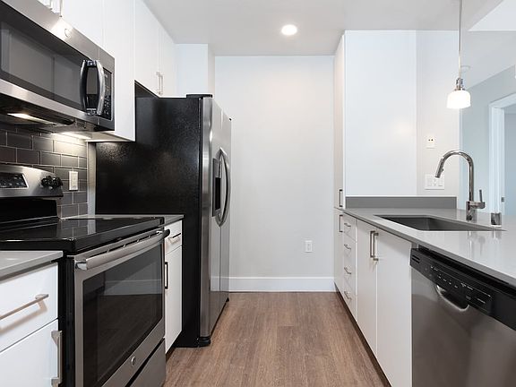 Renovated Phase I kitchen with stainless steel appliances and hard surface flooring
