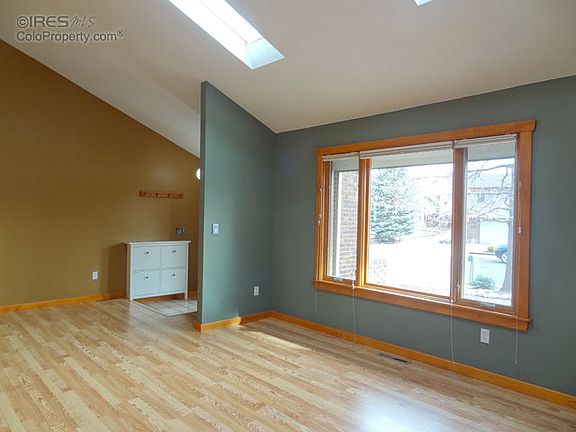 Spacious living room with vaulted ceiling & skylig