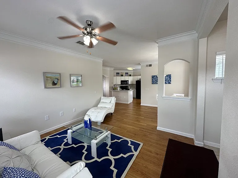 Inviting open-concept living room with cozy seating, modern decor, and a glimpse into a stylish kitchen, perfect for relaxation and entertaining. Inviting open-concept living room with cozy seating, modern decor, and a glimpse into a stylish kitchen, perf