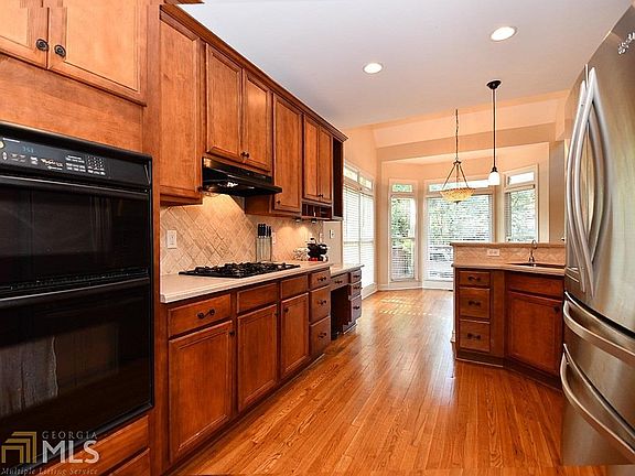 The kitchen has beautiful maple cabinets with a hickory stain, Corian countertops, a separate cooktop and over/microwave, desk area, and a pantry cabinet as well.  There is a sunny breakfast area just adjacent.