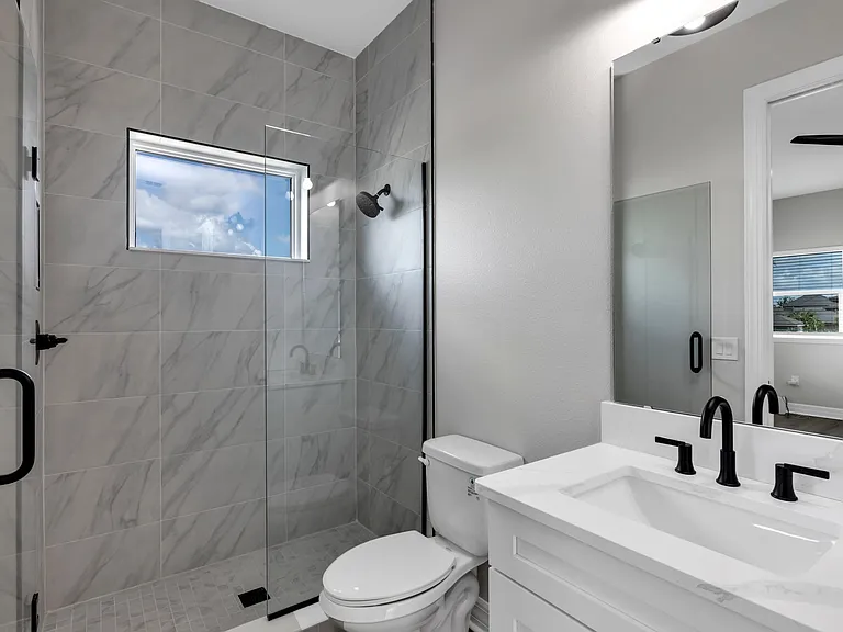 View of bathroom to include shower with door open.