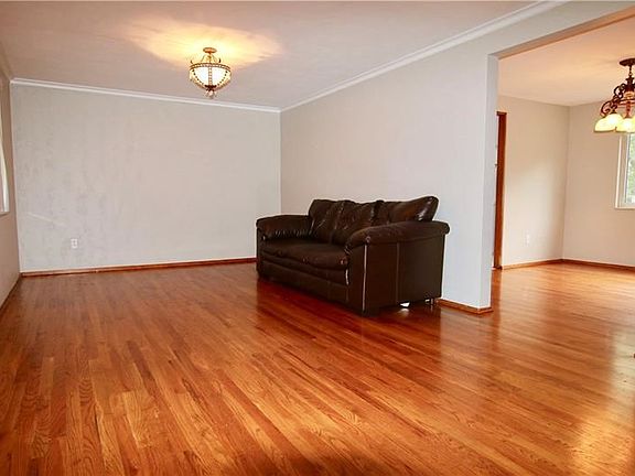 Living room has beautiful refinished hardwoods and is accented with crown moulding.
