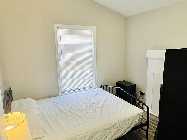 Furnished bedroom with a ceiling fan, window with blinds, and durable wood-look flooring for easy upkeep.