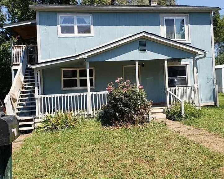 Lower unit has front porch and side covered porch below/under stairs