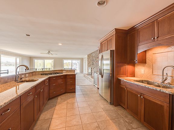 The kitchen will be any chef's delight-- The counter tops are granite and the cabinets are cherry. Both sinks have a disposal and both have touch activated faucets. There is under-cabinet lighting,and both ovens are convection ovens.The wine cooler built-in the kitchen will cool the wine for hot summer evenings