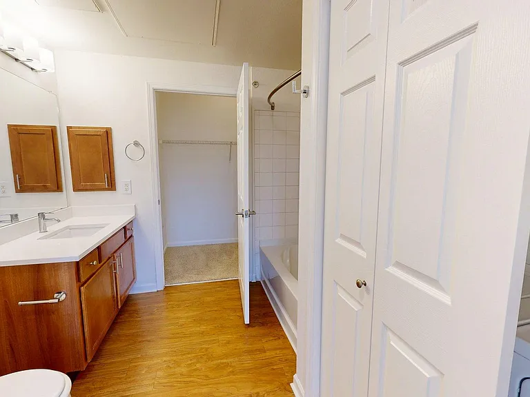Apartment Bathroom with large soaking tub and wood-style floors.