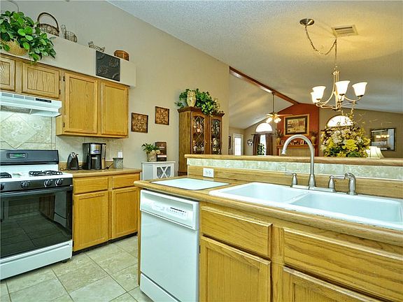 Kitchen with view in the back of the living room. Kitchen, dining room, and living room all in the same area.