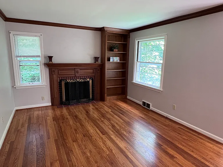 Living area has beautiful hard wood flooring and built in bookshelves.