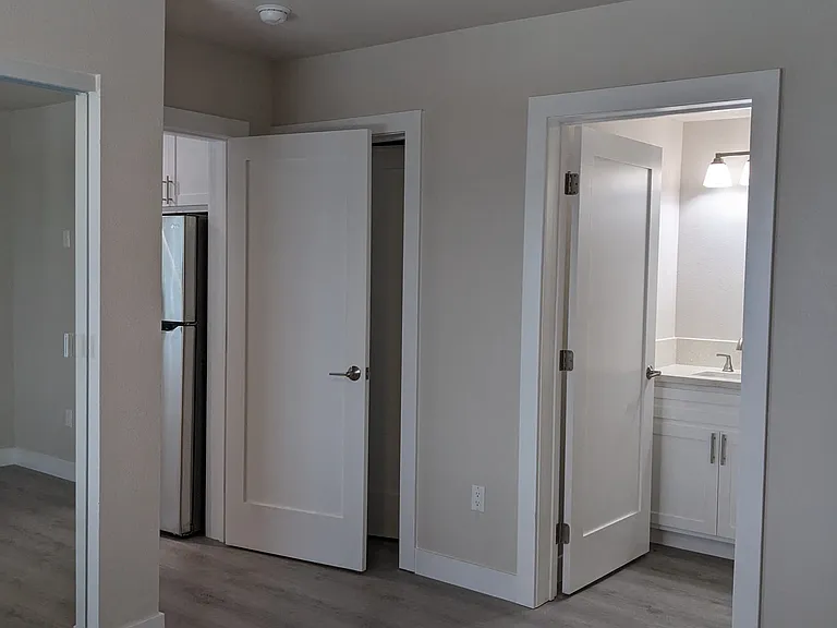 Ensuite bedroom with mirrored closet doors adjacent to the kitchen at The Hardison Apartments in Pasadena, California.
