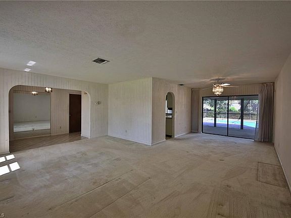 View of lanai, pool and canal from your living room and formal dining area.