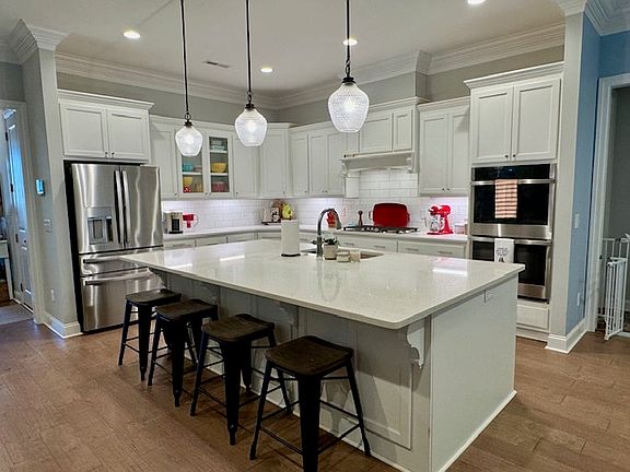 Chef's kitchen with oversized island and gas stove and double ovens.