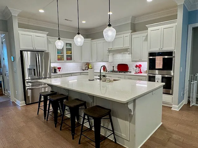 Chef's kitchen with oversized island and gas stove and double ovens.