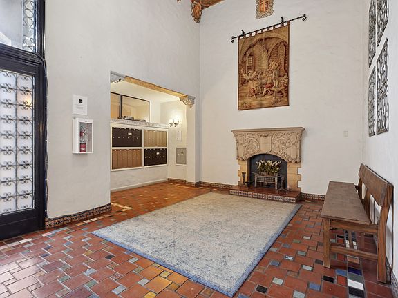 Spacious lobby with a high ceiling, a fireplace with a wooden bench