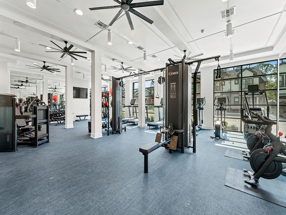 State-of-the-art fitness center featuring modern exercise equipment, high ceilings, and abundant natural light for an invigorating workout experience.
