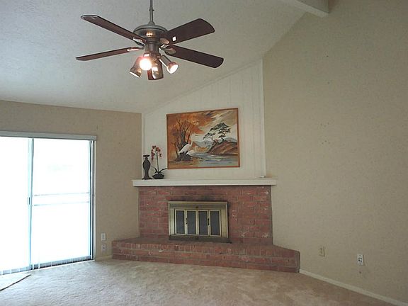 Centrally located family room - high ceiling - raised hearth fireplace - opens onto covered patio and backyard.