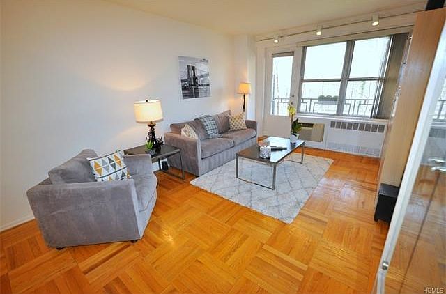 Bright living room has a door leading to a balcony that is great for enjoying the outdoors.  The living room opens to the dining foyer and has parquet floors.  The room is 30'-2" by 12'-4".