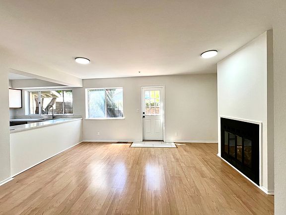 Living room with fireplace and view of backyard. Door opens to backyard.