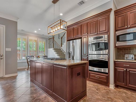 Spacious, open Kitchen has center island with gas cooktop and stainless appliances including double ovens, convection oven and microwave.
