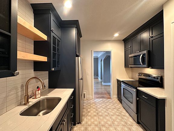 Modern kitchen, newer SS, quartz countertops with custom built-in cabinets and a pantry.
