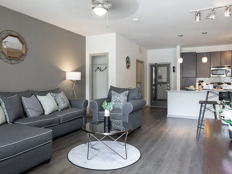 Centro apartments model living room with grey couch and white pillows