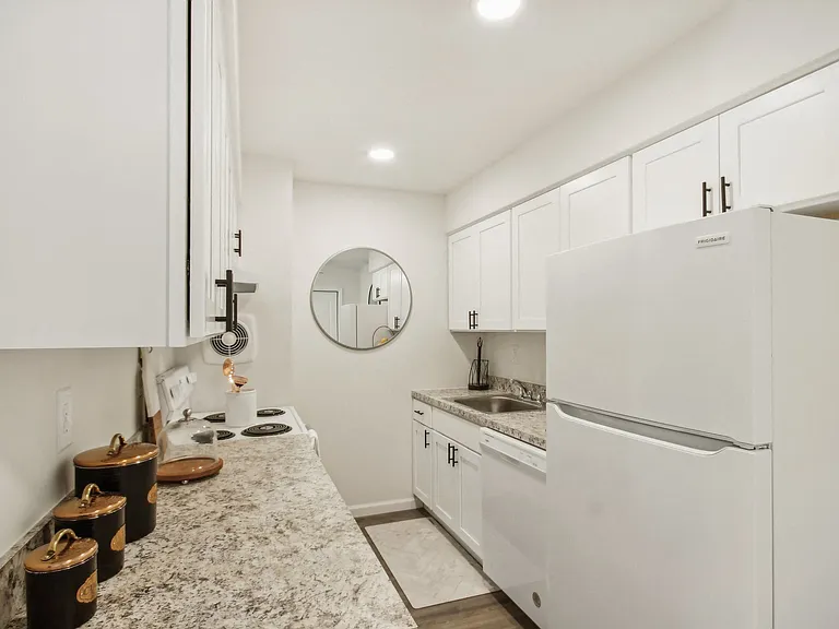 a beautiful white kitchen with white cabinets and a white refrigerator