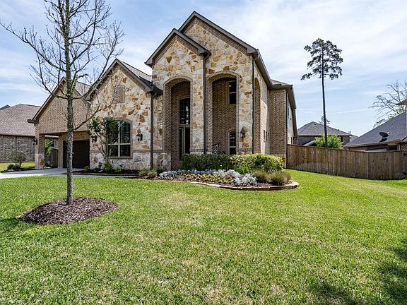 This home offers great curb appeal with a stately exterior of brick and stone! Arched windows and walkways along with flagstone flowerbeds with blooming foliage complete the look!