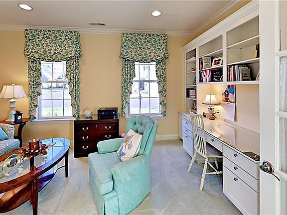 French doors to den/3rd bedroom with built-in shelving and desk.