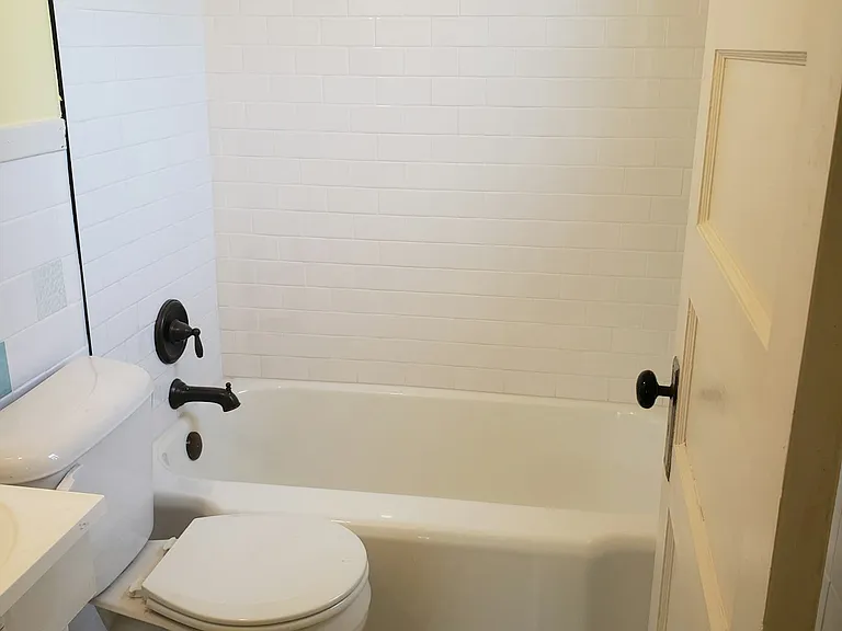 Bathroom. New shower tile and restored bathtub.