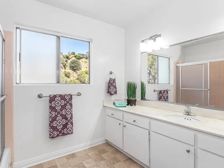 Spacious bathroom on main level with custom features, long countertop and cabinets. Private views.