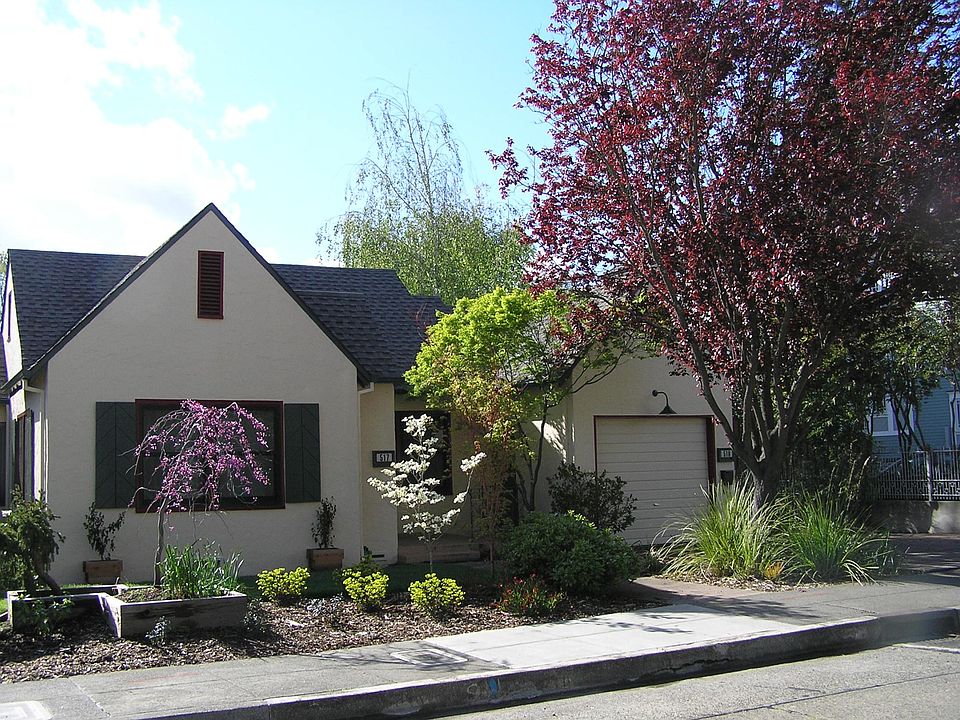 View from the street in spring. The attached garage on right.