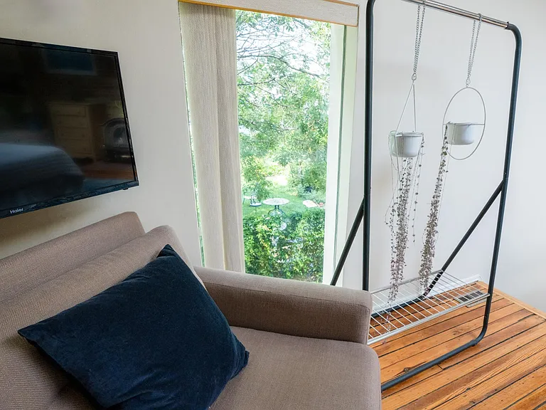 A comfy chair in the bedroom with a view of the community garden.