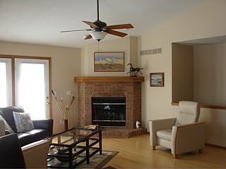 Wood burning fireplace angled between the doorway to the deck and staircase.