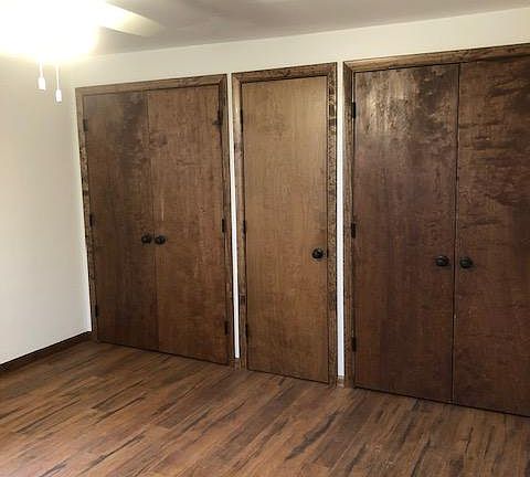 12 x 12 Master bedroom with lots of closet space and wood look vinyl flooring