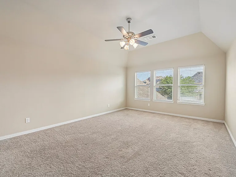 Upstairs bedroom with a ceiling fan.