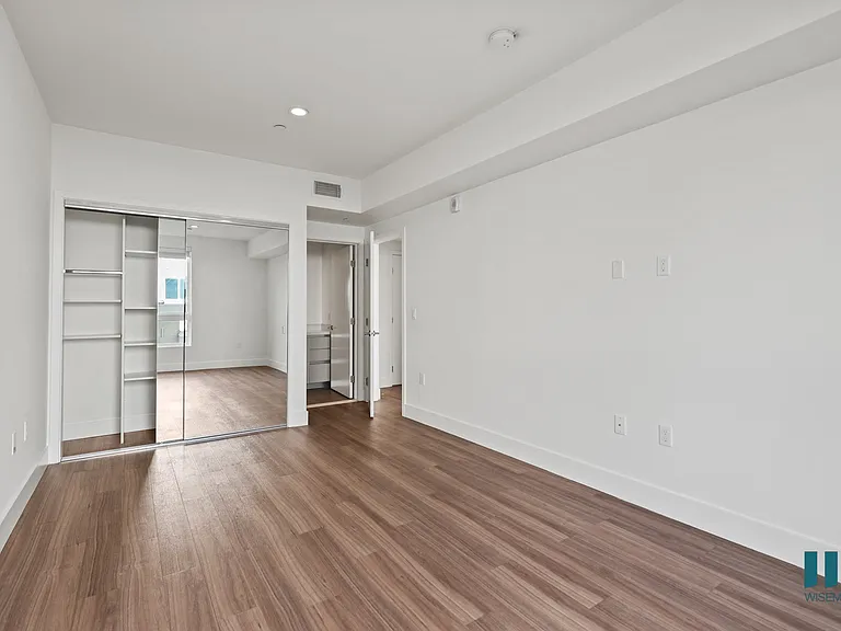 Bedroom with Mirrored Closet with Built-In Shelving, Recessed Lighting, and Vinyl Flooring