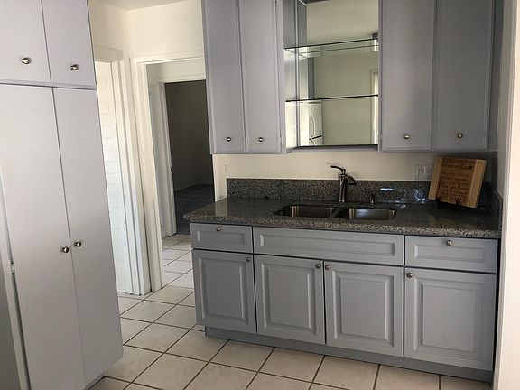 Kitchen with granite counter, large SS sink, newly painted cabinets, tile floors in kitchen, dining area, entry are, easy to keep clean.