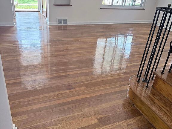 Front entry with built-in shelving, large window, and freshly refinished hardwoods.