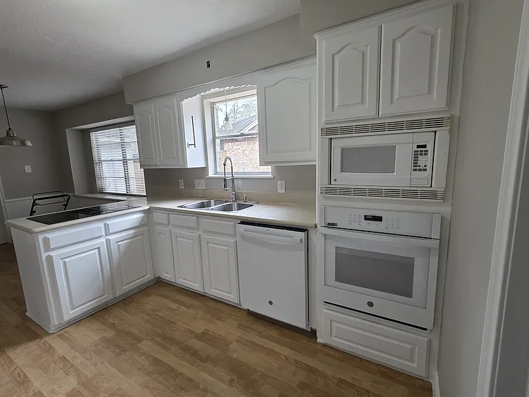 Clean kitchen with range, dishwasher, oven & microwave plus lots of cabinets.