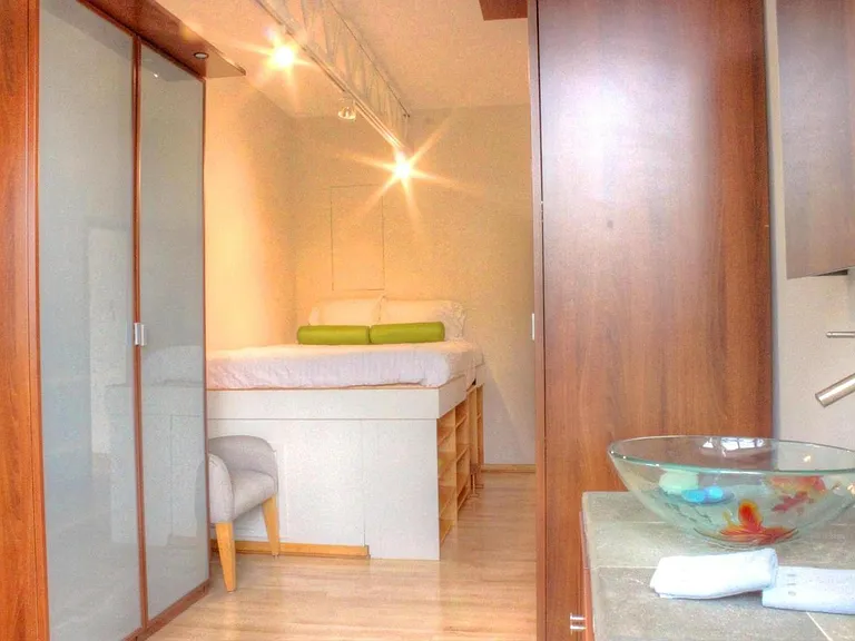 platform bed with closets, bathroom has pocket door between bedroom and bathroom