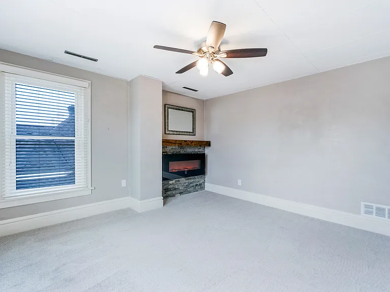living room with electric fireplace with custom stone surround and mantel