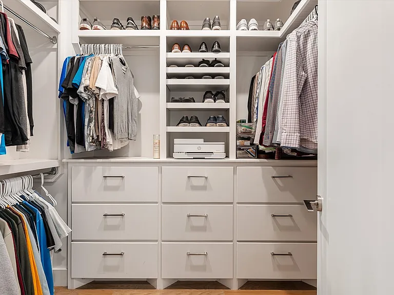 Custom walk-in closet with built-in drawers, shelving, and shoe storage.
