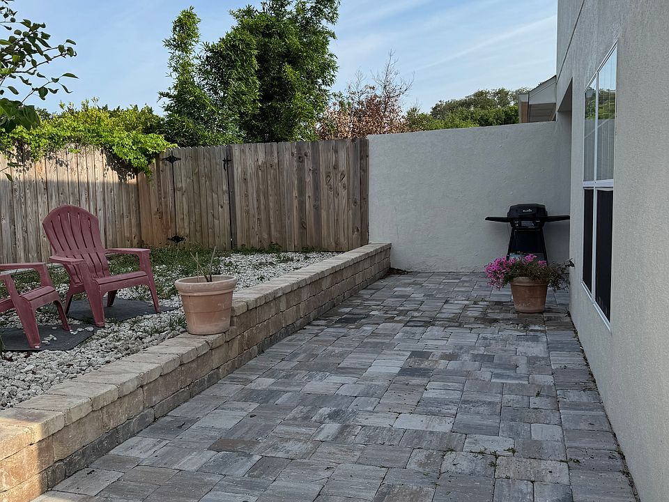 Back porch area with half wall and enclosed in privacy fencing.