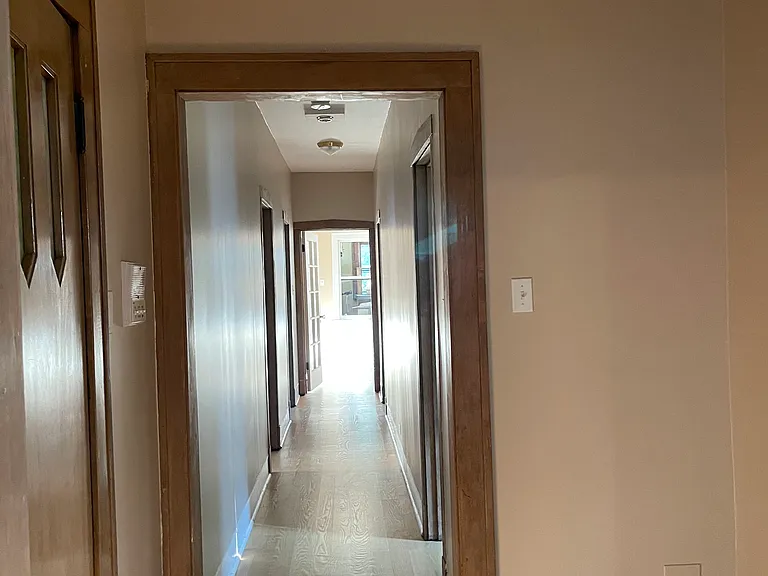 Front door to the left and hallway off of the living room