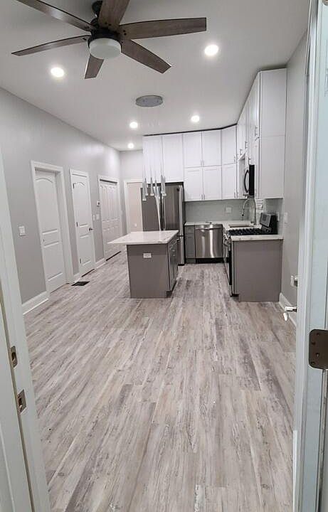 10 foot ceilings . Doors to the walk in kitchen pantry and walk in laundry room seen to the left of the refrigerator.