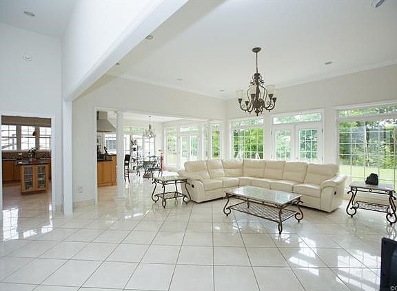 Living room with a bank of windows, beautiful marble floors, gas fireplace.
