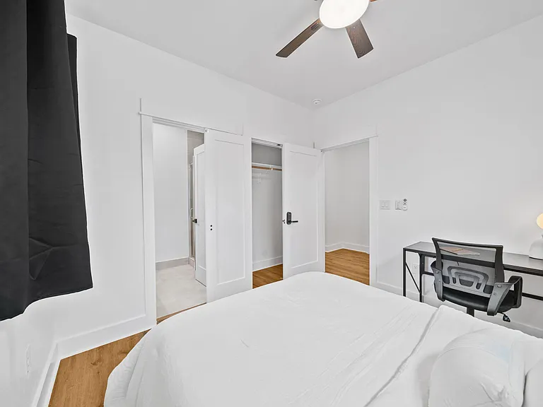 Bedroom with hardwood floors, ceiling fan, desk area, and closet storage with easy access to the bath.