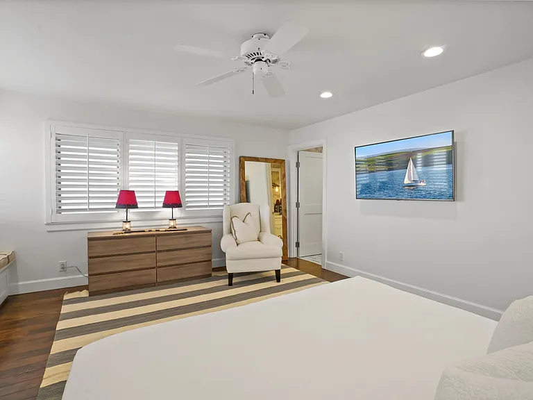 Featuring plush bedding, ceiling fans, natural textures, room darkening shades, and serene coastal decor.