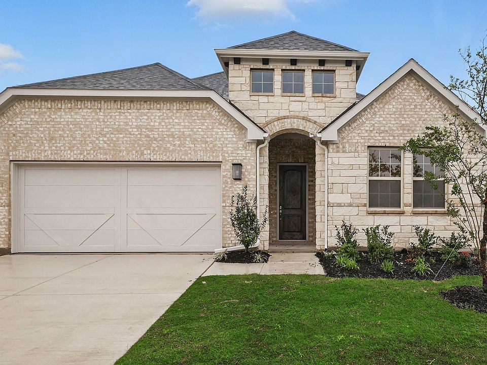 Luxurious brick exterior with arched entryway in Green Meadows Juniper plan.