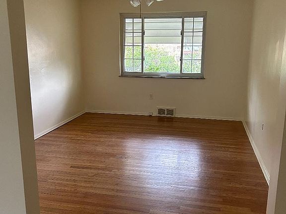 Dining room with ceiling fan and hardwood floors.