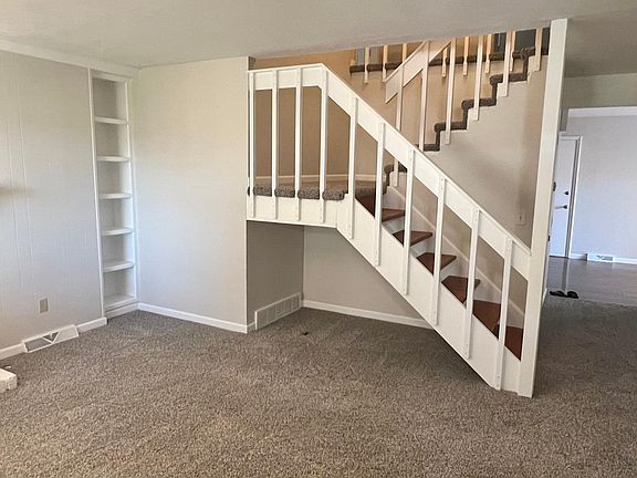 From the living room, make your way into the kitchen area or head upstairs.